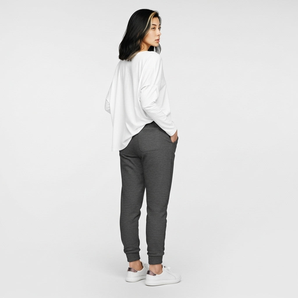 Person wearing a white oversized shirt and gray sweatpants on a white background