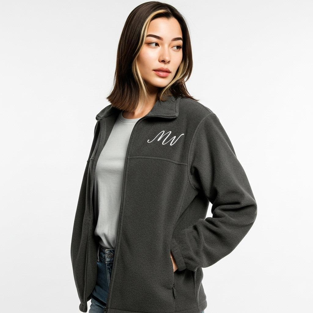 Woman wearing a gray fleece jacket with a logo on a white background