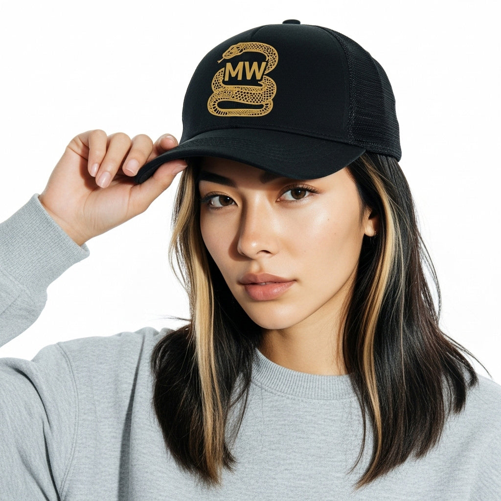 Woman wearing a black cap with a gold logo and text, against a white background